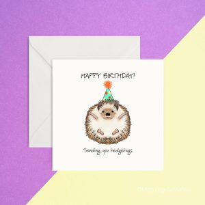 image of a hedgehog on its back with a party hat, words happy birthday sending hedgehugs on it greeting card